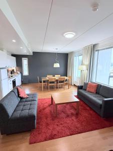 a living room with two couches and a table at Premium Chalet huoneisto kylpylän vieressä in Vierumäki