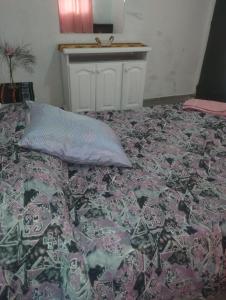 a bed with a blanket and a pillow on it at Areco en lo de Mabel in San Antonio de Areco