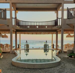 a pool in a pavilion with the ocean in the background at Hotel Blue Note in Hikkaduwa