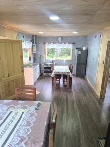 a kitchen and dining room with a table and a refrigerator at Cabaña La Casona in Chaitén