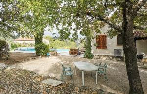 a table and chairs under a tree in a yard at La Champêtre in Fayence