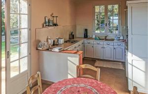 a kitchen with white cabinets and a table with chairs at La Champêtre in Fayence