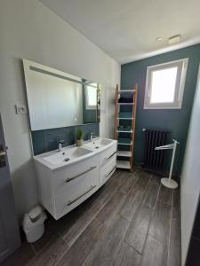 une salle de bains avec un lavabo blanc et un miroir dans l'établissement Cosy la Riveraine Cottage, à Saint-Aignan 20 autres photos