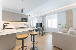 cocina y sala de estar con encimera y taburetes en Guastavino by Alma Suites, en Valencia 152 fotos más