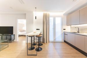 cocina con mesa y 2 taburetes en Guastavino by Alma Suites, en Valencia
