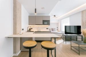 cocina y sala de estar con mesa y taburetes en Guastavino by Alma Suites, en Valencia