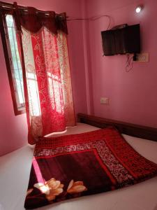 科代卡纳尔G k Holiday的粉色房间里的一张床，挂着红色窗帘。