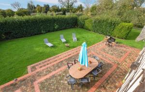 eine Terrasse mit Tisch, Stühlen und Sonnenschirm in der Unterkunft Confortable Maison Normande in Saint-Léger-sur-Bonneville + 34 Fotos