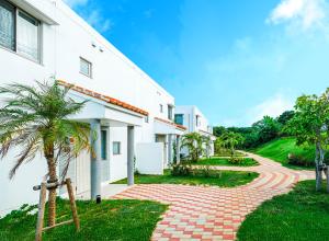 une maison avec une allée en briques à côté d'un bâtiment dans l'établissement Seaside Village 13(シーサイドヴィレッジ・サーティーン), à Ishigaki