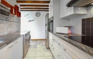 eine Küche mit weißen Schränken und einer Arbeitsplatte in der Unterkunft Confortable Maison Normande in Saint-Léger-sur-Bonneville