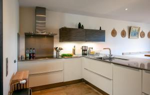 Una cocina con gabinetes blancos y un fregadero. en Amazing Home In Genestelle, en Genestelle