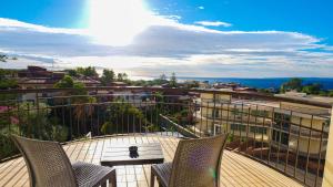 Un balcón con sillas y vista a una ciudad. en 4 Spa Resort Hotel, en Catania