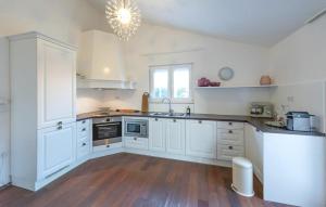 een keuken met witte kasten en een houten vloer bij Stunning Home In Ugljane in Ugljane