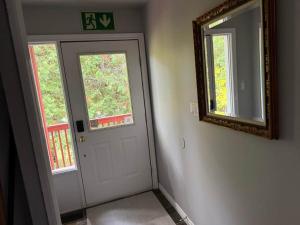 a hallway with a white door and a mirror at 5 Bedrooms, Mountain Views, Steps from Blue Mountain Village, Hot Tub, BBQ in Blue Mountains