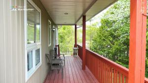 a porch with two chairs and two windows at 5 Bedrooms, Mountain Views, Steps from Blue Mountain Village, Hot Tub, BBQ in Blue Mountains