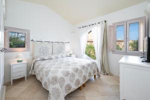a white bedroom with a bed and two windows at Villa Lighthouse 6 - Porto Cervo in Porto Cervo +42 photos