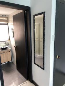 波哥大casa bosque habitación 201的浴室旁墙上的镜子
