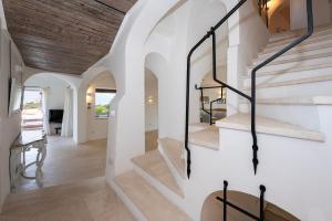 a staircase in a home with white walls and wooden ceilings at Villa Lighthouse 6 - Porto Cervo in Porto Cervo
