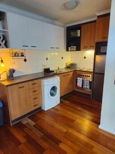 a kitchen with a washer and a washing machine at Quiet, Peaceful Northcote Unit in Melbourne