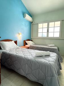 a bedroom with two beds and a window at Pousada Lagoa dos Ventos in Barra de Ibiraquera