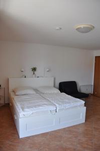 a white bed in a room with a black chair at Ferienwohnung 212 Lagunenstadt in Ueckermünde