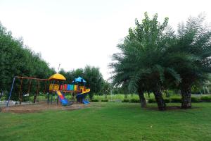 a playground with a slide in a park with a palm tree at Sariska Bliss Farm, #2-BHK, #Private Pool & Garden in Alwar