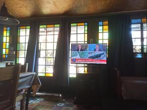 a tv in a room with stained glass windows at Departamento los lapachos in Villa Allende