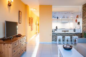 a living room with a television and a kitchen at Apartamento con vistas al mar en el Médano in El Médano +15 photos