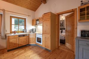 Hannes Appartement in im Zentrum von Kirchberg - by NV-Appartements في كيرشبرغ ان تيرول: مطبخ مع دواليب خشبية وغرفة نوم