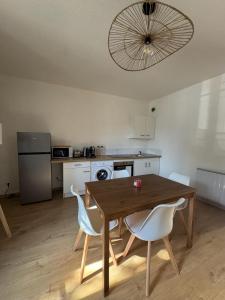 a kitchen with a wooden table and chairs in a room at La Petite Maison mitoyenne in Condeissiat +17 photos
