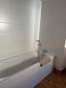a white bath tub with a towel on the side of it at La Petite Maison mitoyenne in Condeissiat