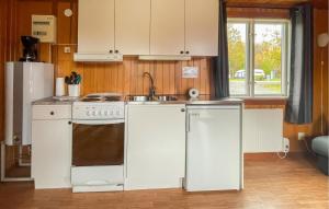 a kitchen with a white stove and a sink at 1 Bedroom Lovely Home In Våxtorp in Jonstorp