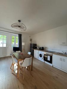 a kitchen with a table and a dining room at La Petite Maison mitoyenne in Condeissiat