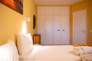 a bedroom with a white bed and a closet at Apartamento con vistas al mar en el Médano in El Médano