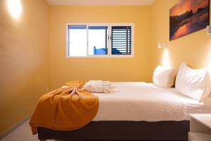 a bedroom with a white bed with a window at Apartamento con vistas al mar en el Médano in El Médano