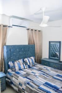 a bedroom with a blue bed with a checkered blanket at Tu rincon Caribeño in San Isidro