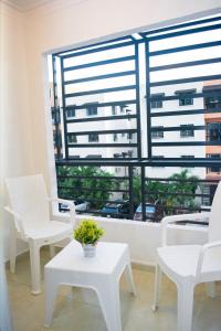 a room with white chairs and a large window at Tu rincon Caribeño in San Isidro