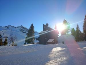 a building in the snow with the sun behind it at Chalet Hauts Forts à Avoriaz - 12 pers, skis aux pieds, terrasse sud, 5 ch, 5 sdb - FR-1-633-33 in Morzine +9 photos