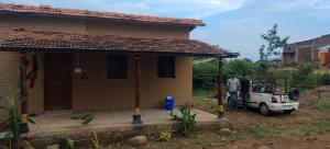 a man standing in front of a small house at Shivalika home stay in Maheshwar +9 photos