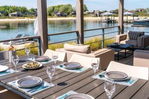 a table on a deck with a view of the water at Villa Super VIP | 4 Pers. (Villa 3) met privéstrand in Ouddorp
