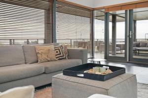 a living room with a couch and a table at Villa Super VIP | 4 Pers. (Villa 3) met privéstrand in Ouddorp