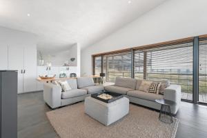 a living room with a couch and a table at Villa Super VIP | 4 Pers. (Villa 3) met privéstrand in Ouddorp +31 photos