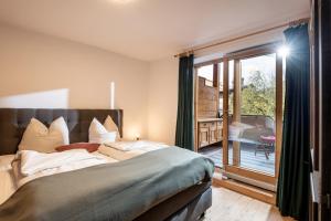 a bedroom with a large bed and a sliding glass door at Petra in Kirchberg in Tirol
