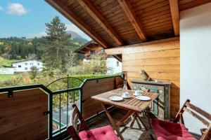 a porch with a table and chairs on a balcony at Petra in Kirchberg in Tirol