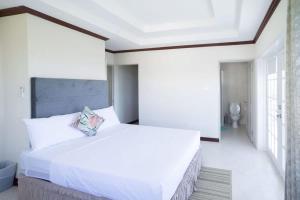 a white bedroom with a large bed and a bathroom at ZenBreak St Silas 6bd in Saint James
