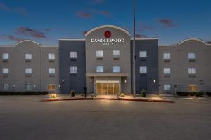 a large building with a sign on the front of it at Candlewood Suites Victoria by IHG in Victoria