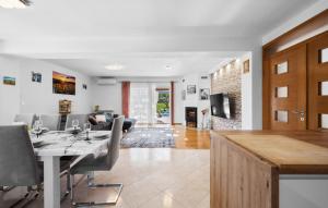 a dining room and living room with a table and chairs at Villa Pleter by Villas Guide in Otavice