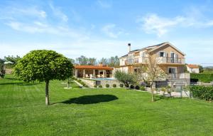 a large house with a yard with a tree at Villa Pleter by Villas Guide in Otavice