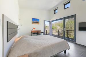 a bedroom with a bed and a desk and a window at Villa Comfort | 6 Pers. (Villa 56) in Ouddorp