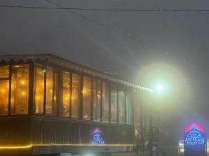 Un vagón de tren en una calle en la niebla en Abhyasi Hotel De Cafe, en Suryodaya